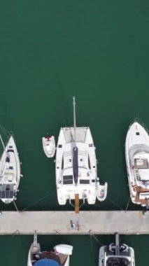 Güzel bir günde limana demirlemiş yatların insansız hava aracı manzarası park etmiş yelkenlilerin ve teknelerin tepeden görünüşü.