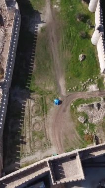 Deniz tarafından inşa edilen tarihi şatonun tepesinden, kale duvarlarının bir görüntüsü ve içindeki yapının görüntüsü.