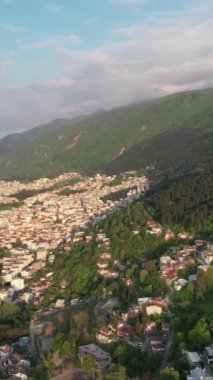 Aerial city built on mountain, drone view of the city settled on the mountainside, urban view of apartments and buildings
