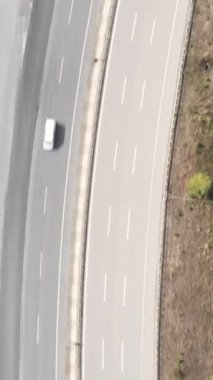 Yazın ağaçlarla çevrili bir otoyolun iki tarafının havadan görünüşü, tarım arazisinden geçen bir otoyol.