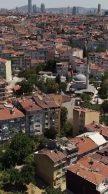 İnsansız hava aracı gökyüzünde kayboldu ve etrafa bakınıyor, tarihi ve kültürel açıdan zengin İstanbul şehri tepeden görünüşü, şehrin inşa ettiği çatı evleri ve sahil manzarası.
