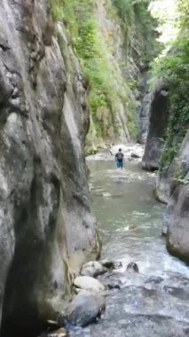 Kanyon nehri havadan manzaralı genç bir adam, doğa yeşil kayaların arasında yürüyor, genç bir kaşif.