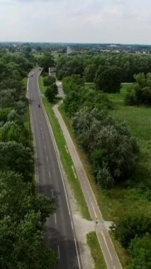 Ağaçlar ve kırsal alanla çevrili bir otoyolun iki tarafını gösteren hava manzarası, tarım arazileri arasındaki yol trafiği.