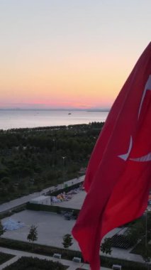 Parkta deniz kenarında sergilenen Türk bayrağı, ülkelerin ulusal sembolleri bayraklar, gün batımında renkli gökyüzünün manzarası