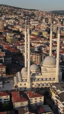 Binalar arasındaki caminin havadan görünüşü, insanlar cami bahçesinde dua ediyorlar, şehrin ortasındaki dini bina.
