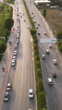 Yol boyunca az sayıda araç ve yolcu bulunan orman ve ağaçların bulunduğu İHA hava yolu manzarası, İstanbul ve Türkiye 'de yeşil santrallerle çevrili yol işaretli kent caddesi