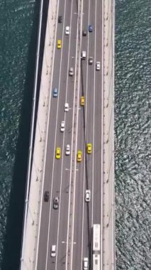 Deniz kıyısında bir şehir olan Boğaz 'ı geçen büyük bir nakliye gemisinin hava görüntüsü, iki tarafı birbirine bağlayan bir köprü.