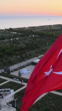 Parkta deniz kenarında sergilenen Türk bayrağı, ülkelerin ulusal sembolleri bayraklar, gün batımında renkli gökyüzünün manzarası