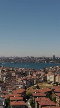 Denize kıyısı olan şehir manzarası, çatısı ve araçları olan evlerin insansız hava aracı görüntüleri.
