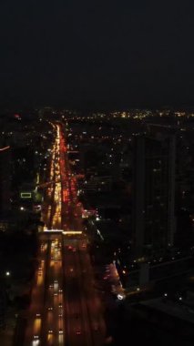 Hava manzaralı gece arabaları trafik, binaların arasından geçen çok şeritli yol trafiği, gece yoğunluğu