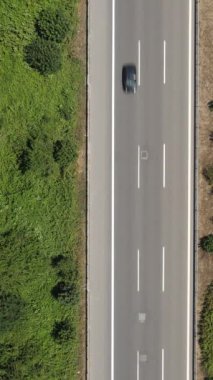 Her iki tarafında kırsal alan olan asfalt yolun havadan görünüşü, otobandan geçen araç trafiğinin yukarıdan görüntüsü