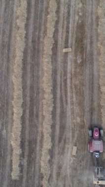 Kırsal bölgelerdeki tarım ekipmanları ve traktör tarafından hasat edilen samanların havadan görüntüsü ile tarımda hasat zamanı