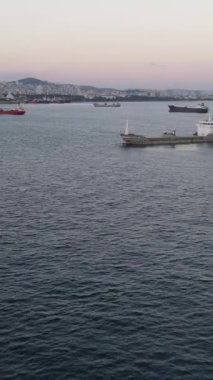 Denize demir atmış gemilerin havadan görünüşü, bir kıyı şehrinde konteynır gemi yoğunluğu, nakliye gemileri.