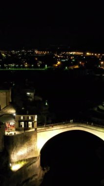 Gece, Mostar Köprüsü 'nün insansız hava aracı görüntüsünü aydınlattı. En çok ışık ve gölge manzaralı tarihi Osmanlı mimarisi.