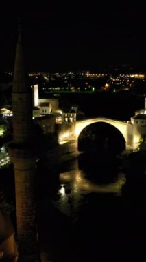 Gece, Mostar Köprüsü 'nün insansız hava aracı görüntüsünü aydınlattı. En çok ışık ve gölge manzaralı tarihi Osmanlı mimarisi.