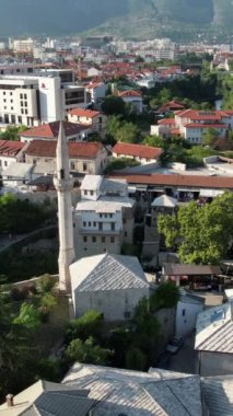 Tarihi şehir Mostar 'ın taştan sokaklarının insansız hava aracı görüntüsü, ağaç ve taş yollardaki günlük yaşam ve sedir mimarisi Tabakci Nezir Ağa Camii görüşü