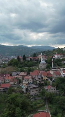 Kültürel ve tarihi Bosna şehrinin insansız hava aracı görüntüleri, fayanslı çatısı ve yeşil doğası olan Bosna şehri, ara sokakları ve yolları olan Travnik şehrinin hava manzarası.