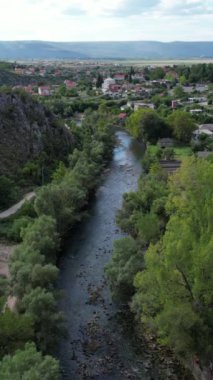 Mostar Bosna 'da kayanın altına inşa edilen Buna Nehri kıyısındaki uçurumlara inşa edilmiş tarihi sufi manastırının insansız hava aracı görüntüleri.