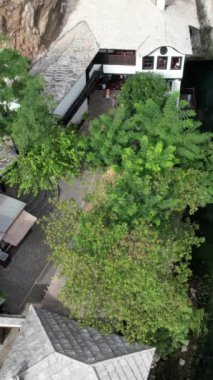 Blagaj kulübesinin hava aracı görüntüsü, kayanın altındaki nehrin üzerine inşa edilen sedir yapısı, Bosna ve Herzegovina 'daki tarihi sufi kulübesi.