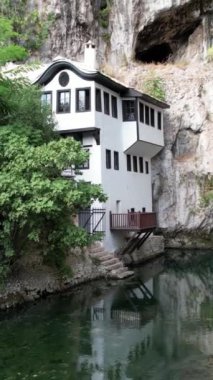 Blagaj şehrinin insansız hava aracı görüntüsü, kayanın altındaki nehir üzerine inşa edilen sedir yapısı, Bosna ve Herzegovina 'daki tarihi sufi kulübesi.
