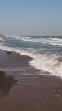 Okyanus dalgalarını kayaların üzerinde seyretmek, gündüz kumsalda romantik yürüyüşler, uçan drone 'lar, deniz kenarında depresyonda yürüyen bir adam.