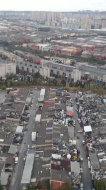 Ufukta gri bulutlu gökyüzünün altında sanayi bölgesi, garajların havadan görüntüsü, sanayi tesisleri, fabrika tüpleri, insansız hava aracı görüntüleri.