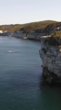 Yakınlardaki turkuaz denizdeki engin beyaz uçurumun insansız hava aracı görüntüsü, koyların etrafındaki deniz manzarası.