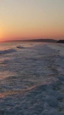 Gün batımında dalgalı denizin hava aracı görüntüsü, renkli günbatımı manzarası, dalgalı deniz manzarası.