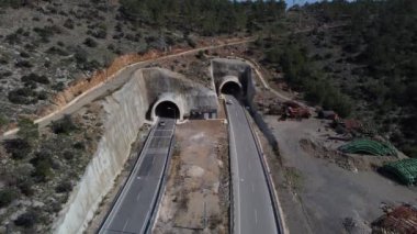 Tünellerin ve yol trafiğinin hava görüntüleri, tünele giren ve çıkan bir sürü kamyonla, inşaat atığı etrafındaki tünel trafiğe açıldı