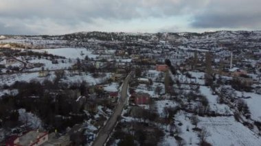 Karlı tepeleri ve dağları olan köyün havadan görünüşü, karlı havada drone 'u olan köyün manzarası, kırsal bölgede evler ve toprak manzarası.
