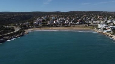 Küçük bir kasabanın havadan görünüşü ve Akdeniz 'in mavi sularında küçük bir körfez kıyı yolundan hareket eden araçların görüntüsü.