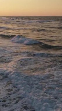 Mavi enerjinin ve berrak okyanus suyunun canlılığı, yukarıdan aşağıya dron çekim perspektifindeki güçlü fırtınalı deniz dalgaları, köpüklü beyaz dokuyla denizdeki dalga çizgilerini çarpıştırmak.