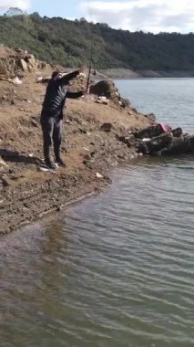 Hava aracı gölde balık tutan genç bir adam görüyor. Yüksek kalite, nehirde balık tutan yalnız bir adam.