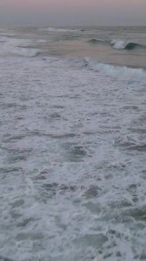 Mavi enerjinin ve berrak okyanus suyunun canlılığı, güçlü fırtınalı deniz dalgaları yukarıdan aşağıya dron çekim perspektifi, köpüklü beyaz dokuyla denizdeki dalga çizgisini çarpıştırıyor.