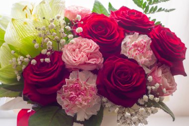 A bouquet of flowers with red roses as a gift for the holiday.