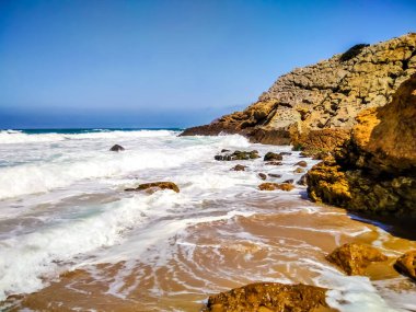 Portekiz kıyıları. Cascais sahillerinden birinde kristal berrak su var. Sörf yapmak için harika bir yer..