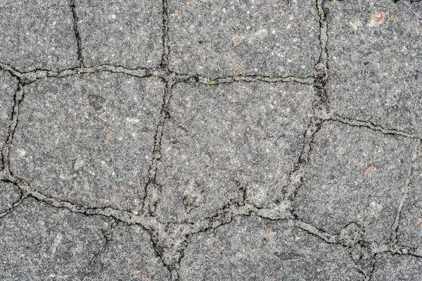 Cracked road surface caused by external factors.