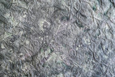 Arka plan olarak gri boyayla kaplanmış buruşmuş kağıt..