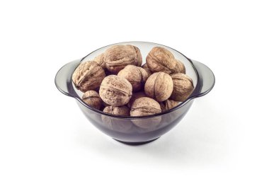 Beyaz arka planda cam bir kasede fındık.