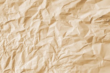 Arkaplan olarak sıcak bej şeklinde buruşmuş büyük bir kağıt yaprağı..