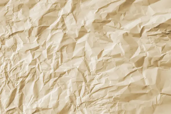 Arkaplan olarak sıcak bej şeklinde buruşmuş büyük bir kağıt yaprağı..