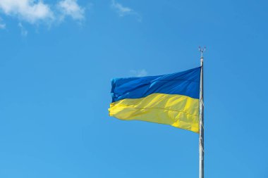 Ukrayna bayrağı açık mavi gökyüzüne karşı rüzgarda dalgalanıyor..