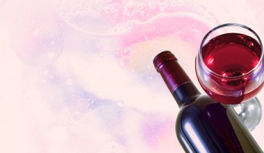 Pastel arka planda bir şişe kırmızı şarap ve cam..