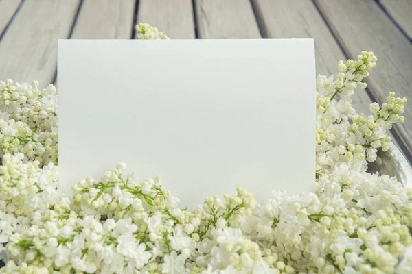 白纸卡片 带有特写的白色紫丁香花和木制背景 — 图库照片