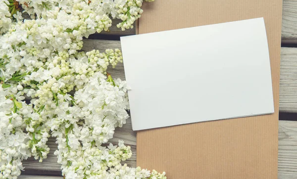 白纸卡片 带有特写的白色紫丁香花和木制背景 顶部视图 — 图库照片
