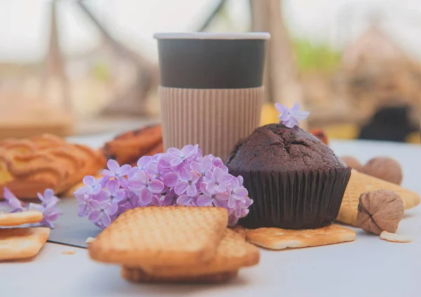 Paper Cup Assorted Pastries Chocolate Muffin Lilac Flowers Outdoor Cafe — Stock Photo, Image