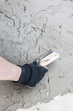 Decorative plaster coating, master making the texture of venetian plastering on the wall, hand with trowel