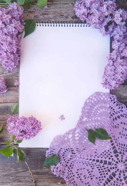 空のノートブックリストトップビューモックアップとともにライラック花とかぎ針編みナプキン — ストック写真