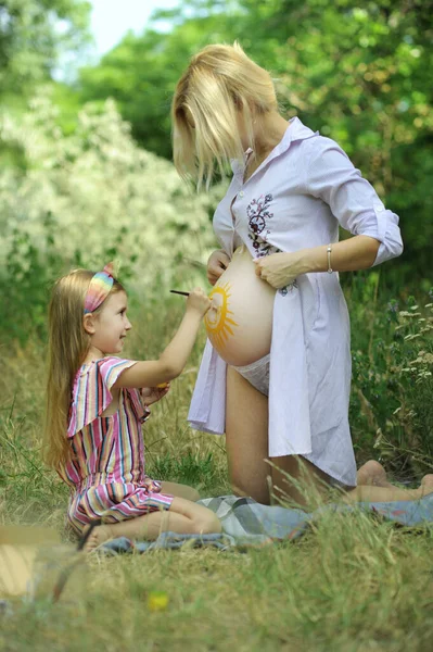 Küçük Mutlu Kız Hamile Annenin Karnına Güneşi Boyuyor Parkta — Stok fotoğraf