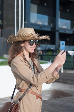 Gülümseyen mutlu kadın açık hava portresi, hasır şapkalı gezgin kadın açık havada fotoğraf çek.